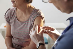 Older woman getting a shot from a doctor
